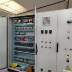 Armoire électrique ouverte avec borniers et porte de commande