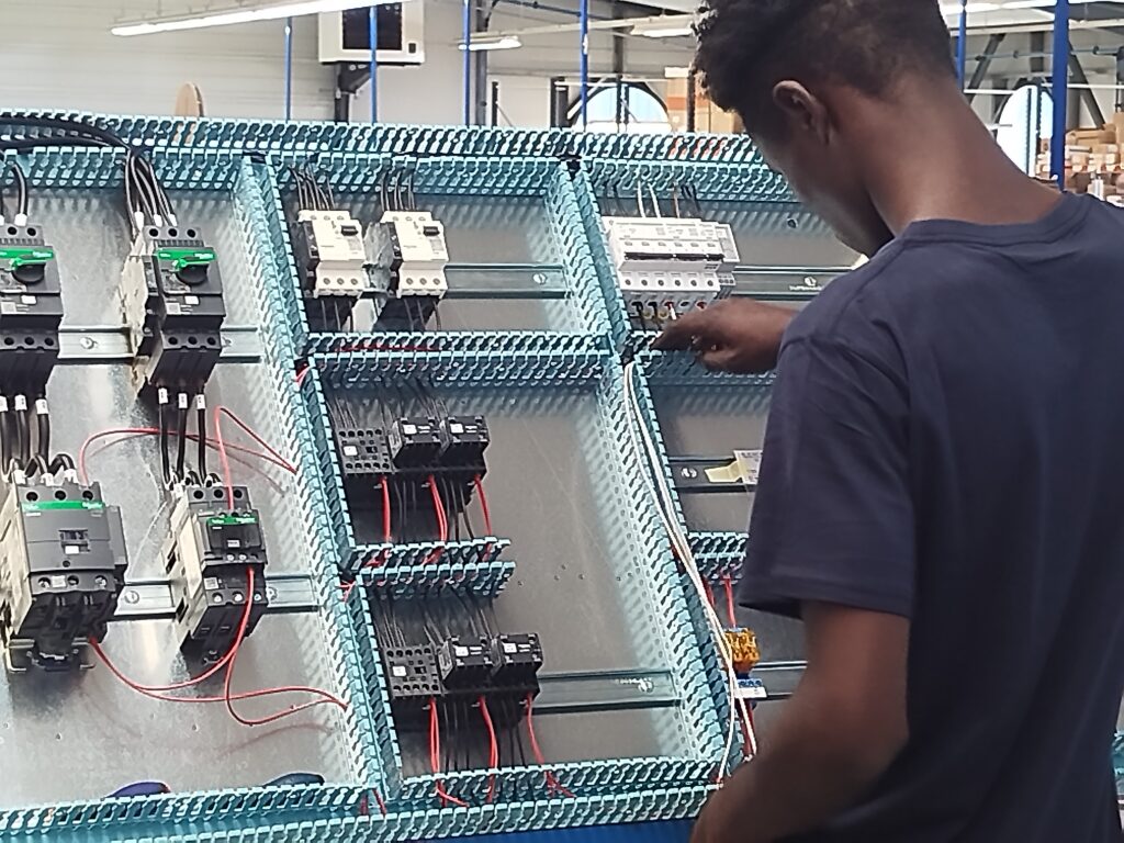 Technicien câblant des platines électriques en atelier