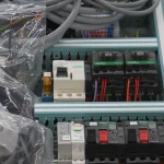 Platine électrique avec disjoncteurs et contacteurs en cours de câblage