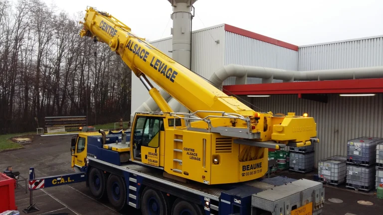 Machine industrielle levée par une grue lors d'un transfert d'usine